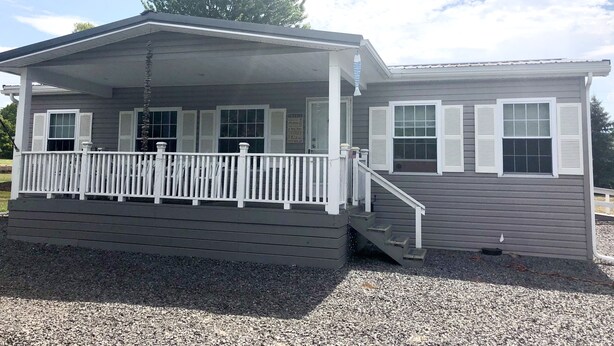 A two-story building with a covered porch and a small staircase leading to the upper level.