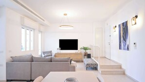 A modern living room with a sofa, a coffee table, and a TV.