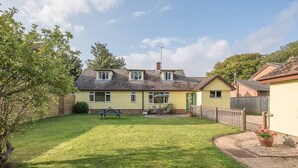 A two-story house with a well-maintained lawn, a picnic table, and a small garden area. - The Spinney, Saxtead near Framlingham (Woodbridge)