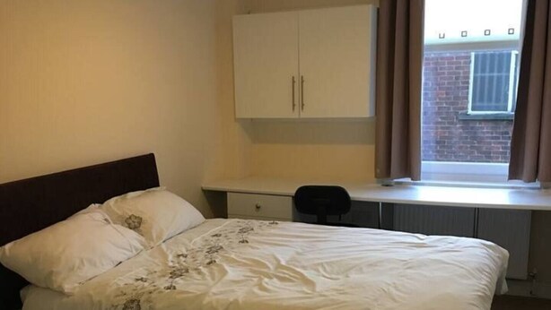 A bedroom with a bed, a desk, a chair, and a wardrobe. - Impeccable 3-bed Apartment in Stockton-on-tees (Stockton-on-Tees)