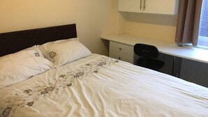A bedroom with a bed, a desk, and a chair. - Impeccable 3-bed Apartment in Stockton-on-tees (Stockton-on-Tees)