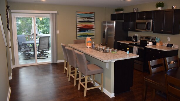 A modern kitchen with dark cabinets, a stainless steel refrigerator, and a built-in microwave. - Comfortable, Beautiful Townhome in quaint neighborhood w/ patio deck (Henrico)