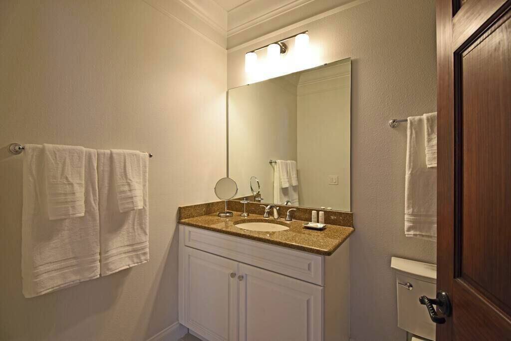 A bathroom with a sink, mirror, and towel rack.