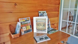 Une table en bois, sur laquelle sont disposées des brochures et un panneau encadré portant le nom « Oregon Hill Four Seasons ».