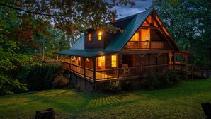 A log cabin with a porch, a covered deck, and a well-maintained lawn. - Beautiful Views of the Smoky Mountains! Hot Tub-Game Room-3 King Beds-Sleeps 11 (Sevierville)