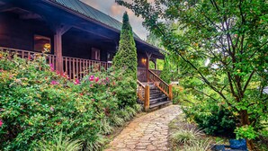 A wooden cabin with a stone pathway leading to a wooden staircase. - Beautiful Views of the Smoky Mountains! Hot Tub-Game Room-3 King Beds-Sleeps 11 (Sevierville)
