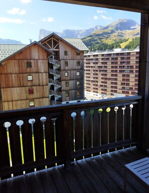 A wooden building with a balcony and a view of a mountain range. - Comfortable 4-person apartment with 2 bedrooms (Le Dévoluy)