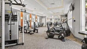 Ein Fitnessraum mit unterschiedlichen Trainingsgeräten, darunter Kraftgeräte und Cardiogeräte.