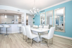 Una cocina moderna con armarios blancos, una isla central e iluminación colgante.
