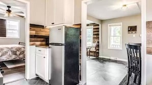 Una cucina moderna con frigorifero integrato, elementi in legno e zona pranzo con tavolo e sedie.
