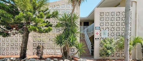 A building with a geometric facade, a private entrance sign, and a staircase leading to the entrance.