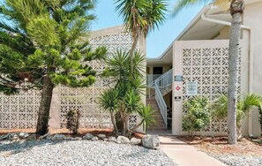A building with a geometric facade, a private entrance sign, and a staircase leading to the entrance. - MERMAID’S COVE**Cozy condo two blocks from the beach (Cape Canaveral)
