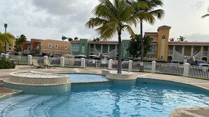 Piscina com várias áreas e um deck ao redor.