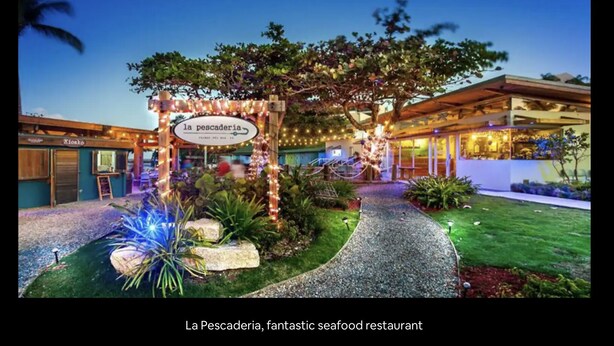 La Pescadería, um restaurante de frutos do mar com área externa bem iluminada, uma placa e um caminho que leva à entrada.