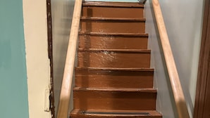 A wooden staircase with a handrail, leading to a landing. - Charming Farmhouse on a working farm. (Pittsfield)