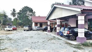A building with a red roof and a covered parking area.