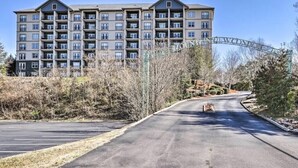 A multi-story apartment building with a parking lot in front. - Close To It ALL with Indoor & Outdoor Pools (Pigeon Forge)