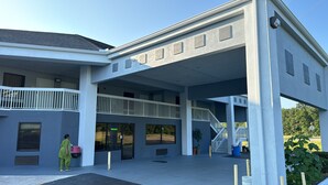 A modern building with a covered entrance, a balcony, and a staircase leading to an upper level. - Westen Motel (Scooba)