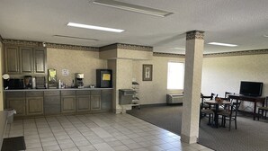 A spacious kitchen with modern appliances, a dining area with a TV, and a large window providing natural light. - Westen Motel (Scooba)