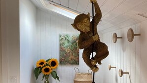 A wooden dresser with a vase of sunflowers and a woven basket.