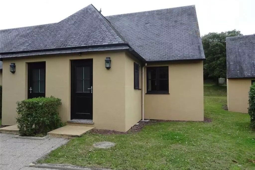 Un edificio a un piano con tetto a due falde, una porta d'ingresso e un piccolo portico.