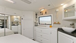 A modern bathroom with a large mirror, a sink, and a window with a view of the outdoors. - Large Glamper w/ Hot Tub and full bathroom-sleep 6 (Capon Bridge)