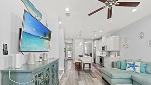 A modern kitchen with white cabinets, a central island, and a ceiling fan. - Sandy Palms ~ Pet-Friendly Coastal Retreat with Golf Cart & Game Loft (Panama City Beach)