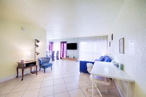 Relax in this open-plan living area with a flat-screen TV, comfortable seating, and a dining table.