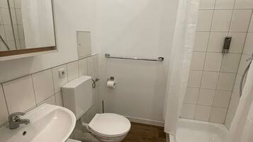 Ein Badezimmer mit Waschbecken, Toilette und Dusche.