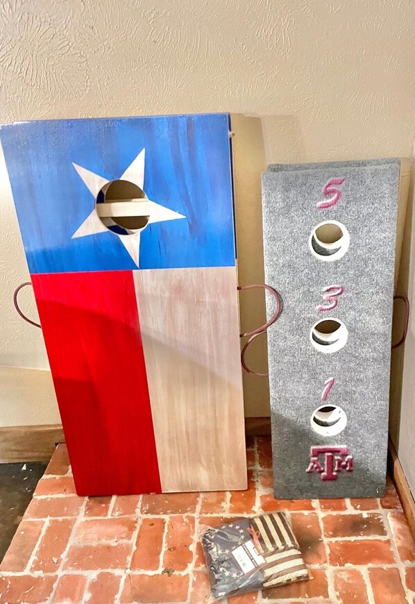 Two wooden structures with Texas flags, one with a star and stripes, and the other with a crescent moon and stars. - Secluded Whoop Acre Ranch SLEEPS 25-LOADED with entertainment (Bryan)