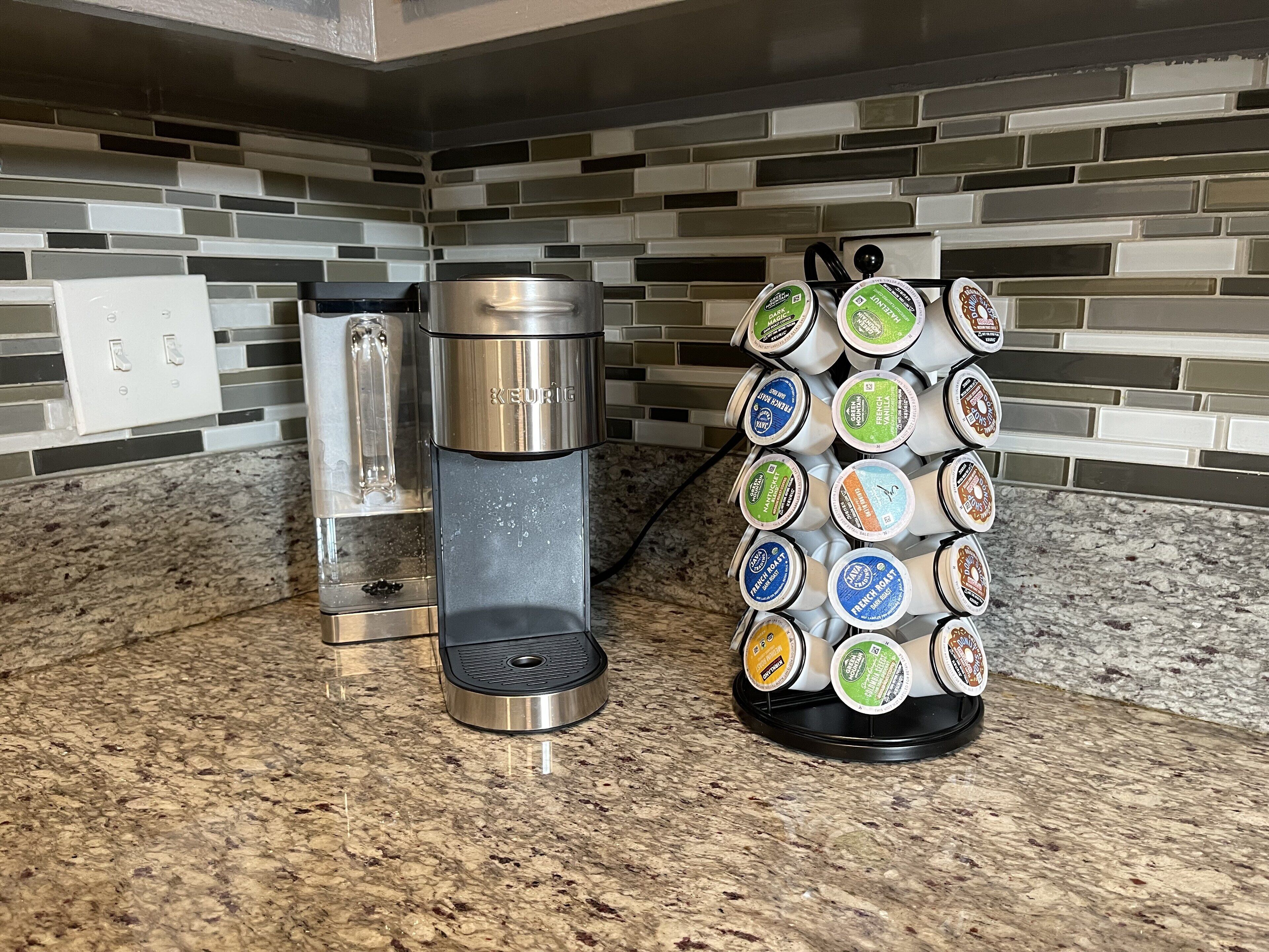 A kitchen with a coffee maker and a coffee pod holder.