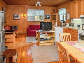 A cozy cabin interior with a wooden interior, a television, a dining table, and a kitchen area. - Peukaloinen b1 by Interhome (Kuusamo)