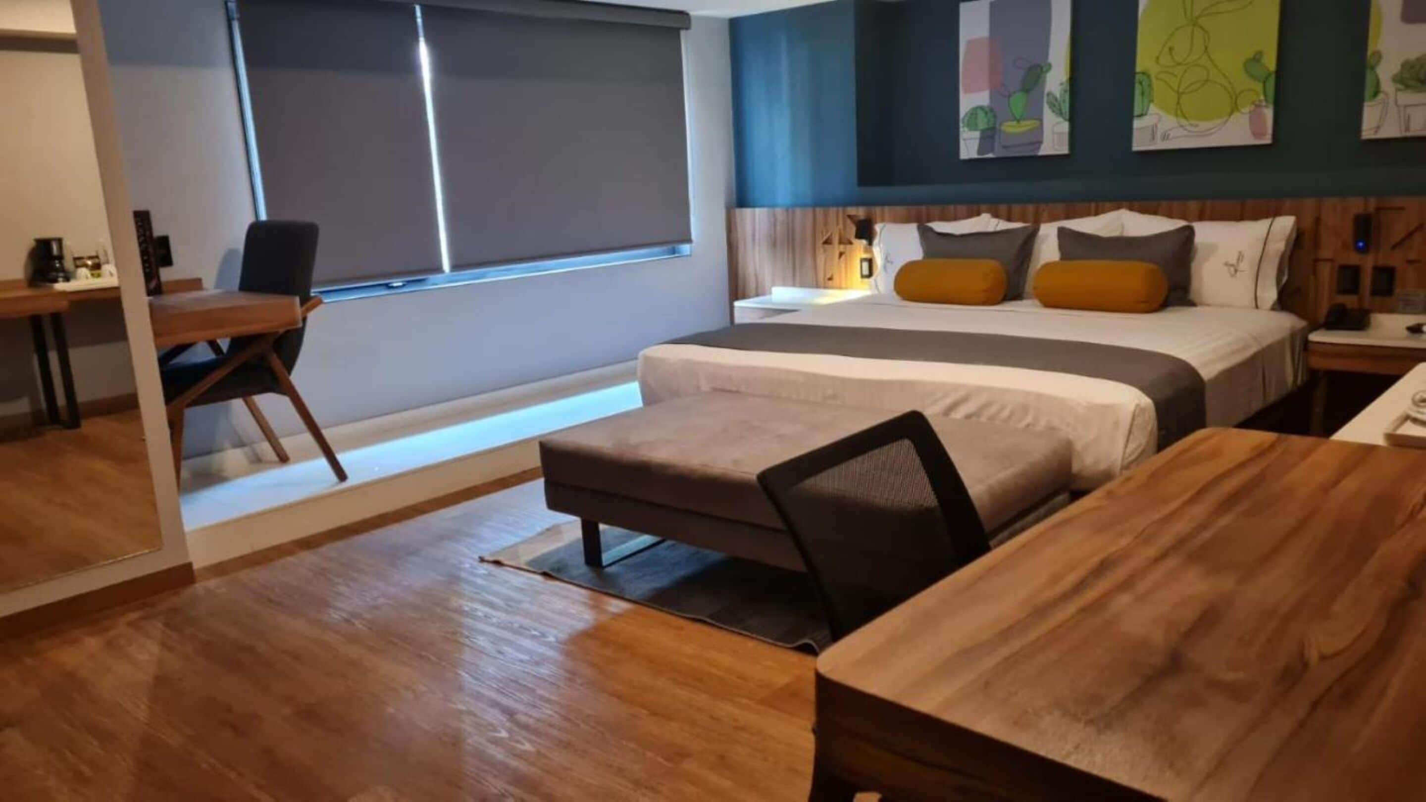 Een moderne hotelkamer met een bed, een bureau en een stoel.