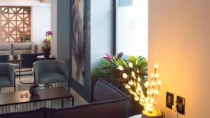 A modern interior with a seating area, a decorative wall, and a unique light fixture.