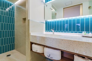 Une salle de bain avec un lavabo, un miroir et des murs recouverts de carreaux bleus.