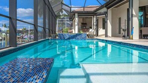 An indoor swimming pool with clear glass walls, a tiled floor, and a view of the outside.