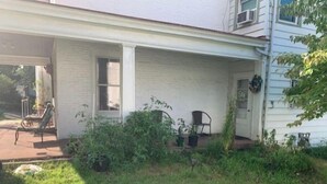 A house with a covered porch, a small garden, and a window. - Wonderful Home (Pottstown)