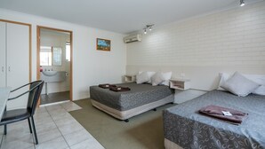 A hotel room with a bed, a desk, and a chair. - Capella Hotel Motel (Capella)