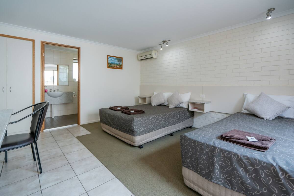 Habitación de hotel con cama, escritorio y una silla.
