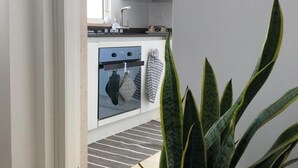 A modern kitchen with white cabinets, a built-in oven, and a striped rug. - in the Heart of the City of Bari (Bari)
