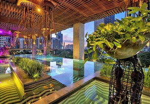 An indoor pool with a glass bottom, surrounded by plants and a bamboo ceiling. - The Orient Jakarta, a Royal Hideaway Hotel (Jakarta)
