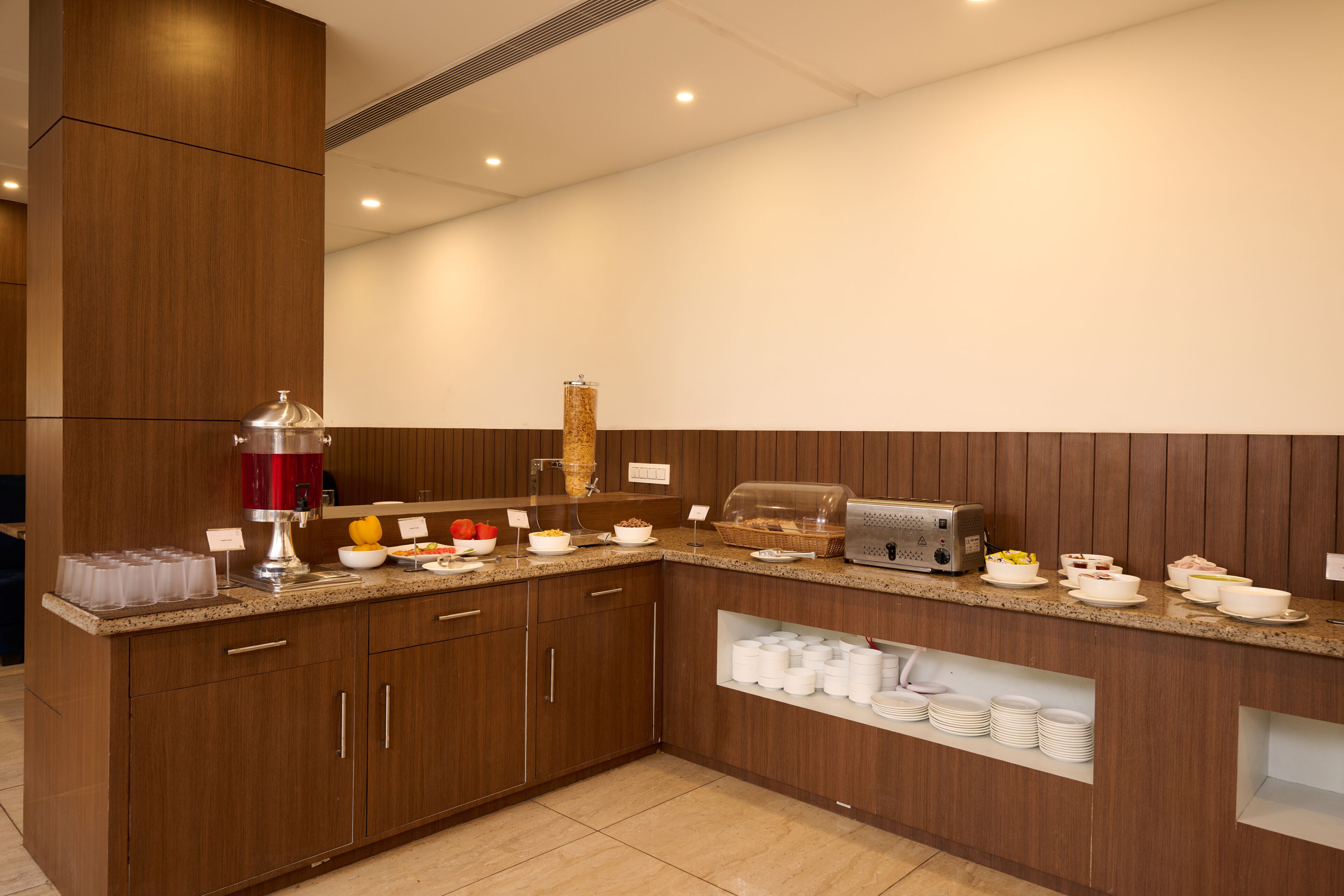A modern kitchen with wooden cabinets, a granite countertop, and various food items and appliances.