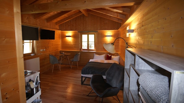 A cozy cabin-style room with a bed, a desk, and a chair. - Kargl's alpine hut (Bad Kohlgrub)