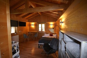 A cozy cabin-style room with a bed, a desk, and a chair. - Kargl's alpine hut (Bad Kohlgrub)