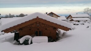 A wooden cabin with a snow-covered roof, surrounded by snow. - Kargl's alpine hut (Bad Kohlgrub)