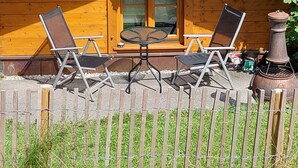 A wooden cabin with two folding chairs and a table outside. - Kargl's alpine hut (Bad Kohlgrub)