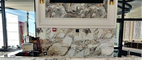 A reception desk with a marble countertop and a sign that reads "KOZA HOTEL".