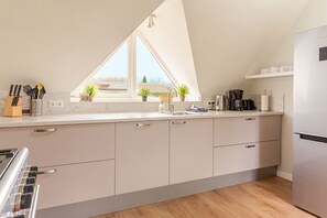 A modern kitchen with a large window, a built-in oven, and a coffee maker.