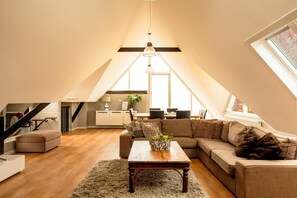 Relax in this inviting attic space with a central coffee table, comfortable sofa, and modern kitchen area.