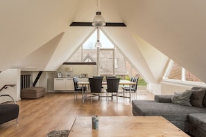 A modern loft with a dining area, kitchen, and seating space.